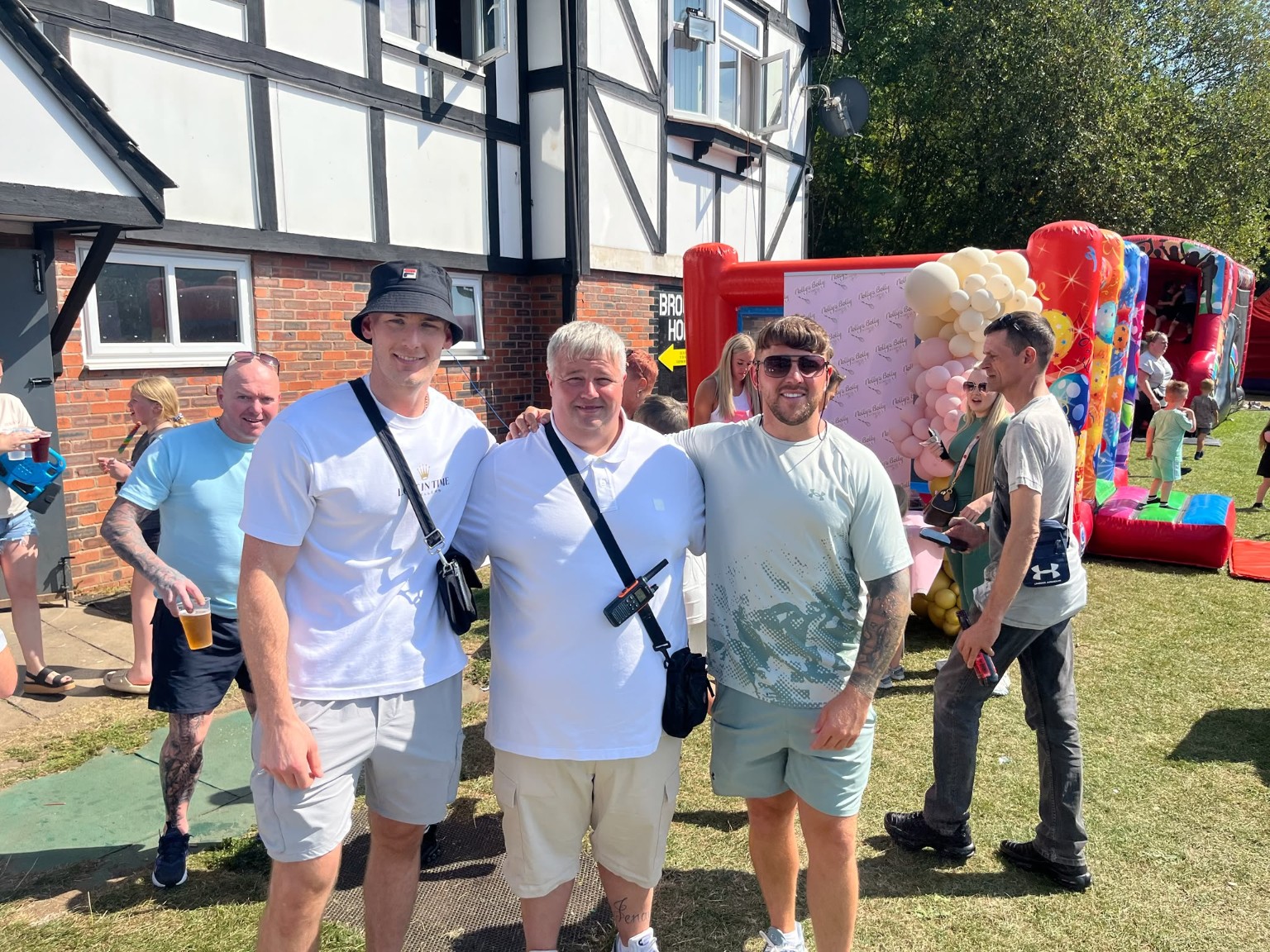 Community members enjoying the Platinum Promotions family fun day with bouncy castle in the background